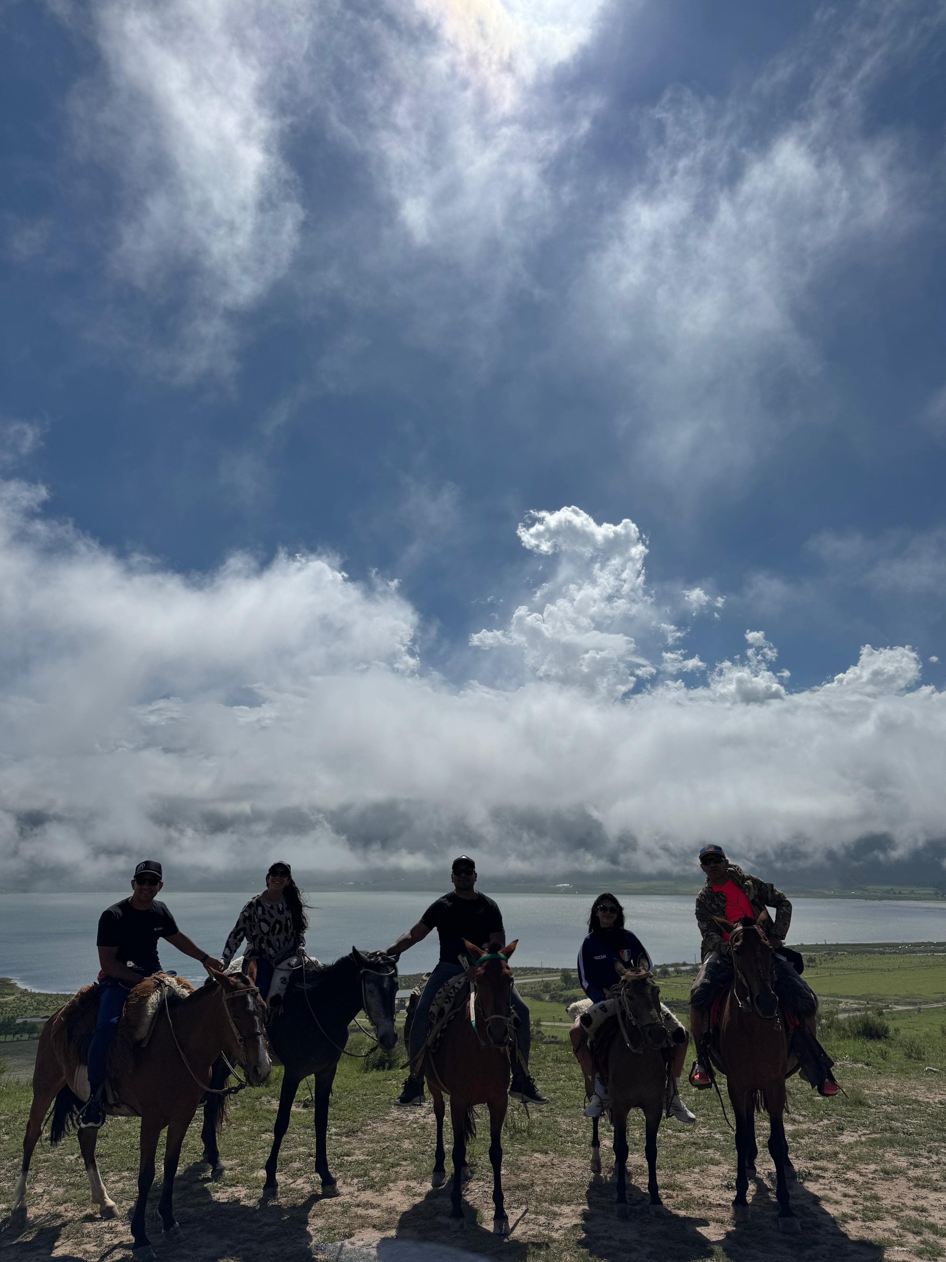 Grupo grande disfrutando una cabalgata especial frente al Dique La Angostura, El Mollar